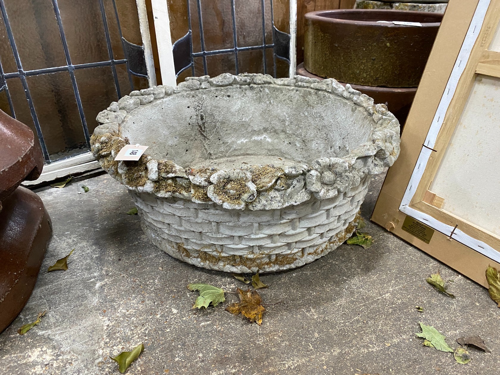 A circular reconstituted stone basket weave garden planter with floral rim, diameter 60cm, height 23cm